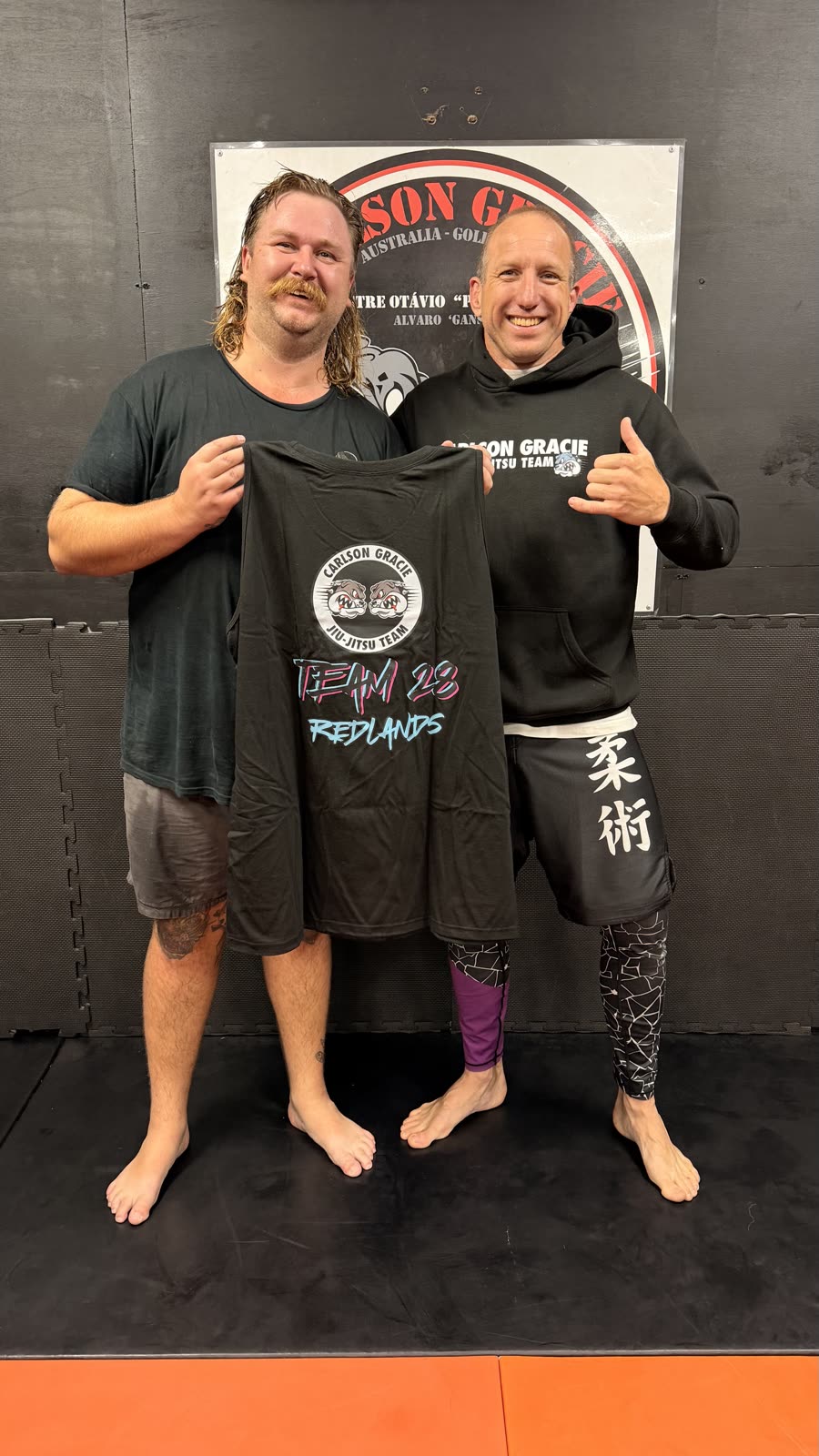 Ben Ladlow with member receiving Team 28 Redlands tank top